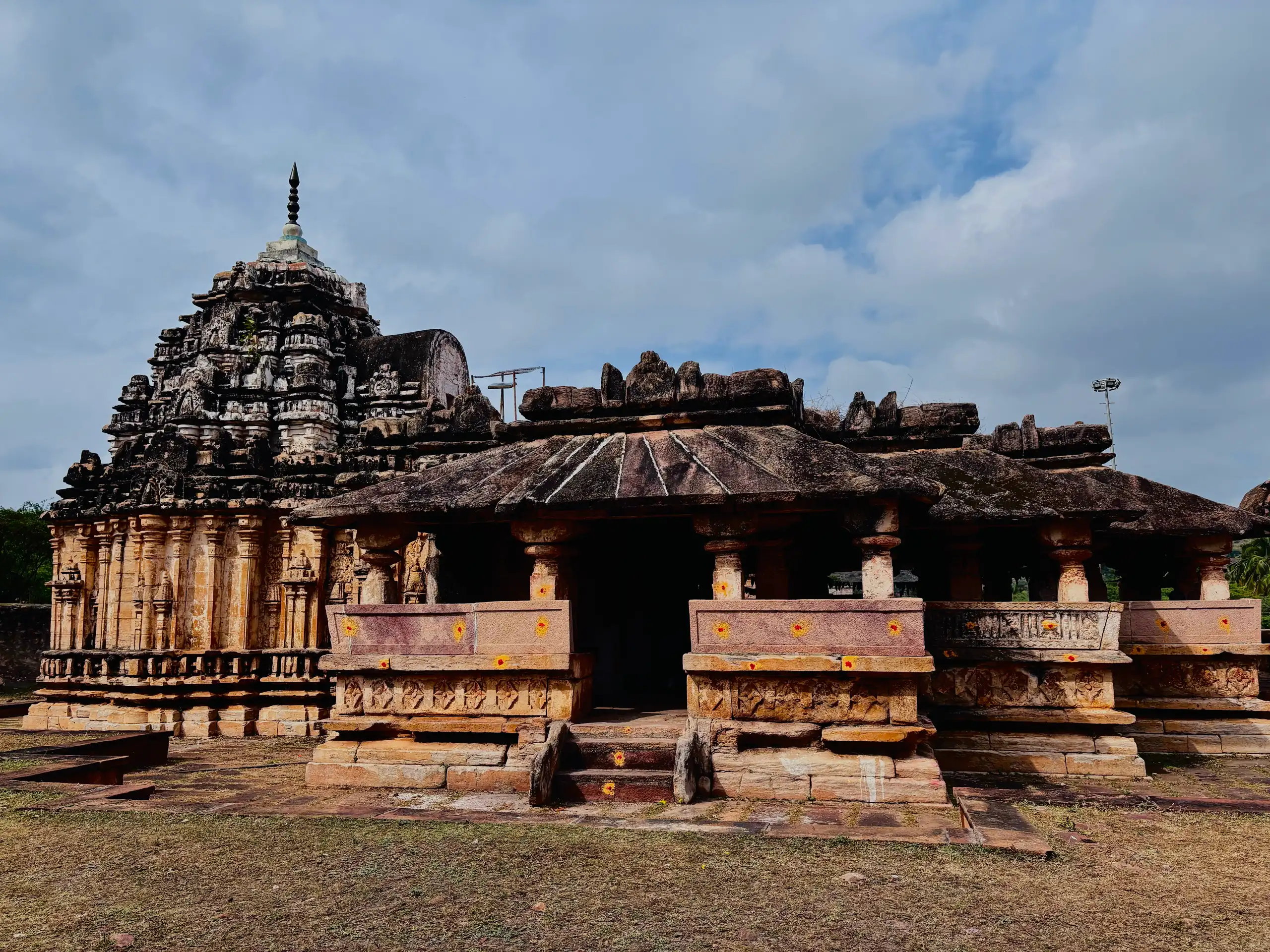 The temple at Torgal under a heavy monsoon sky, its shikhara rising above a pillared hall