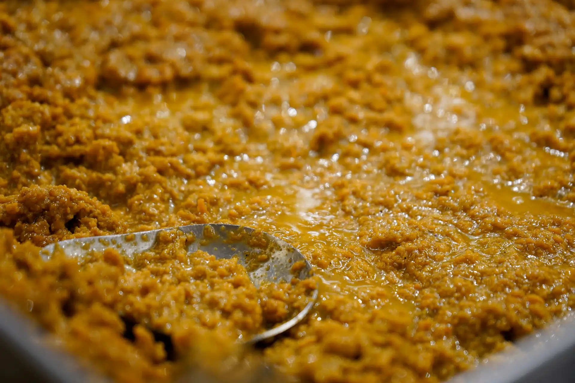 Belagavi kunda being stirred in a wide pan, caramel-gold and glistening