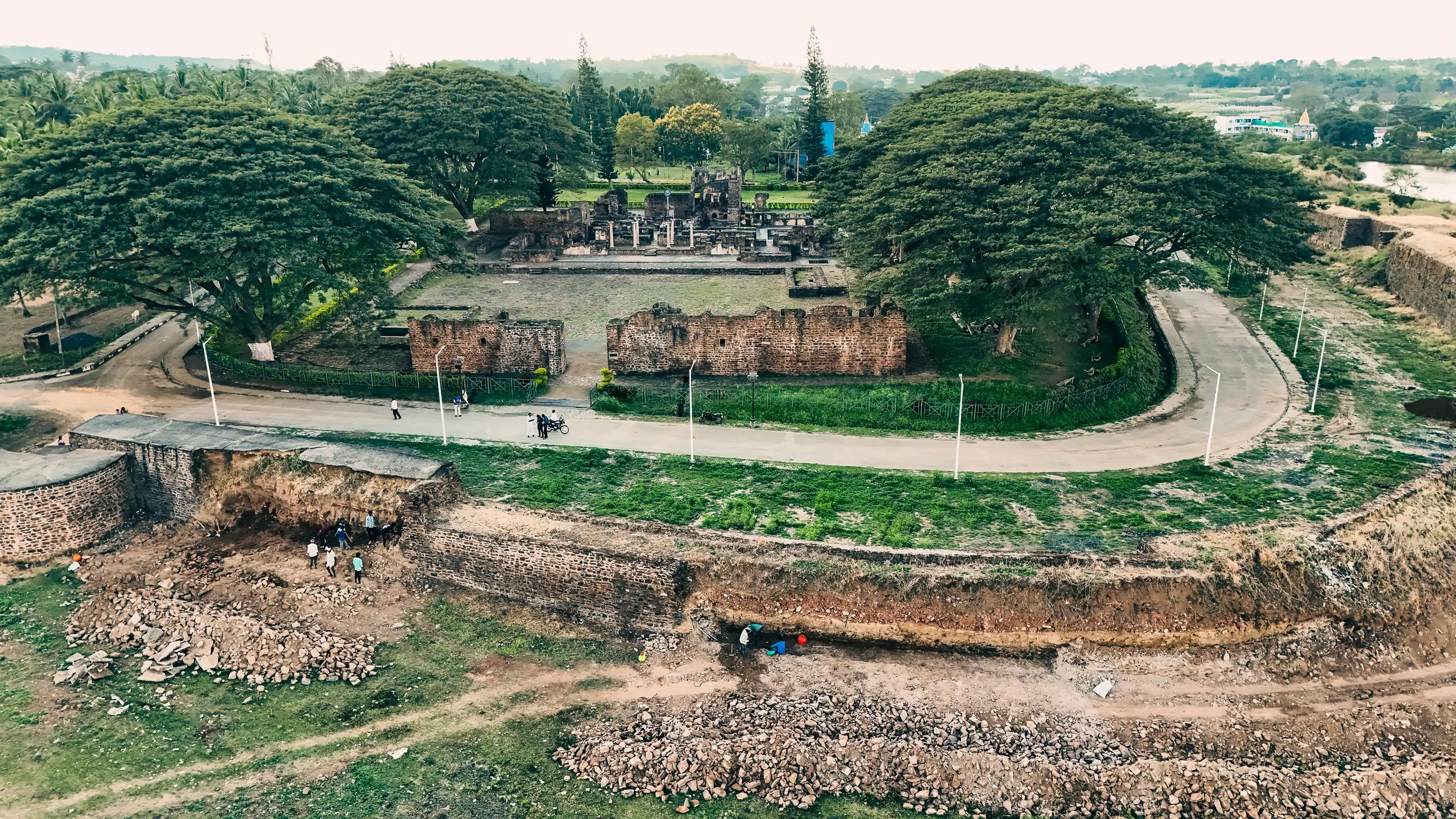Aerial view of Kittur Fort's ramparts and the ruined durbar hall, framed by rain trees