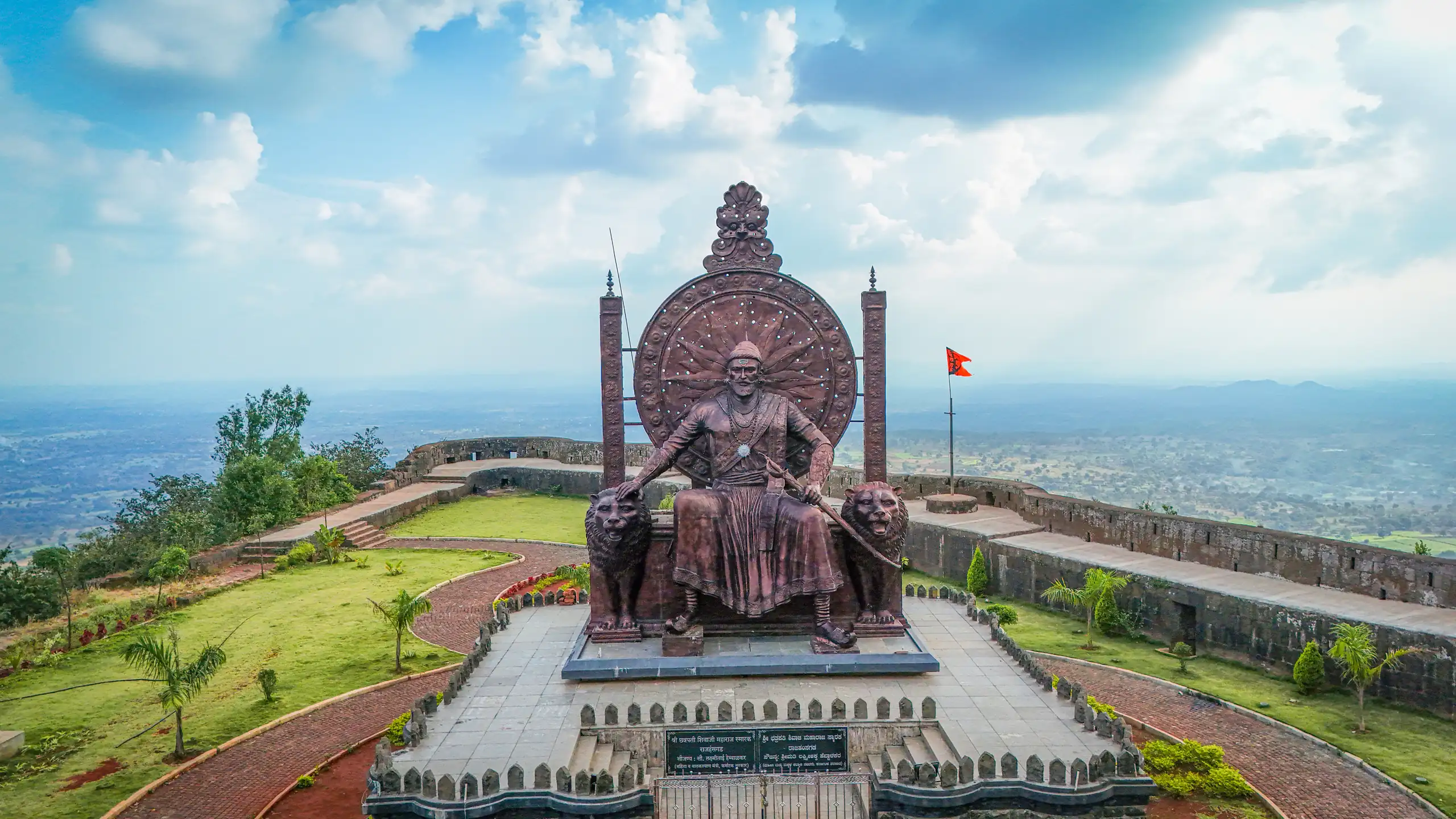 The Shivaji Maharaj memorial at Yellur Fort, seated between stone lions above the plains